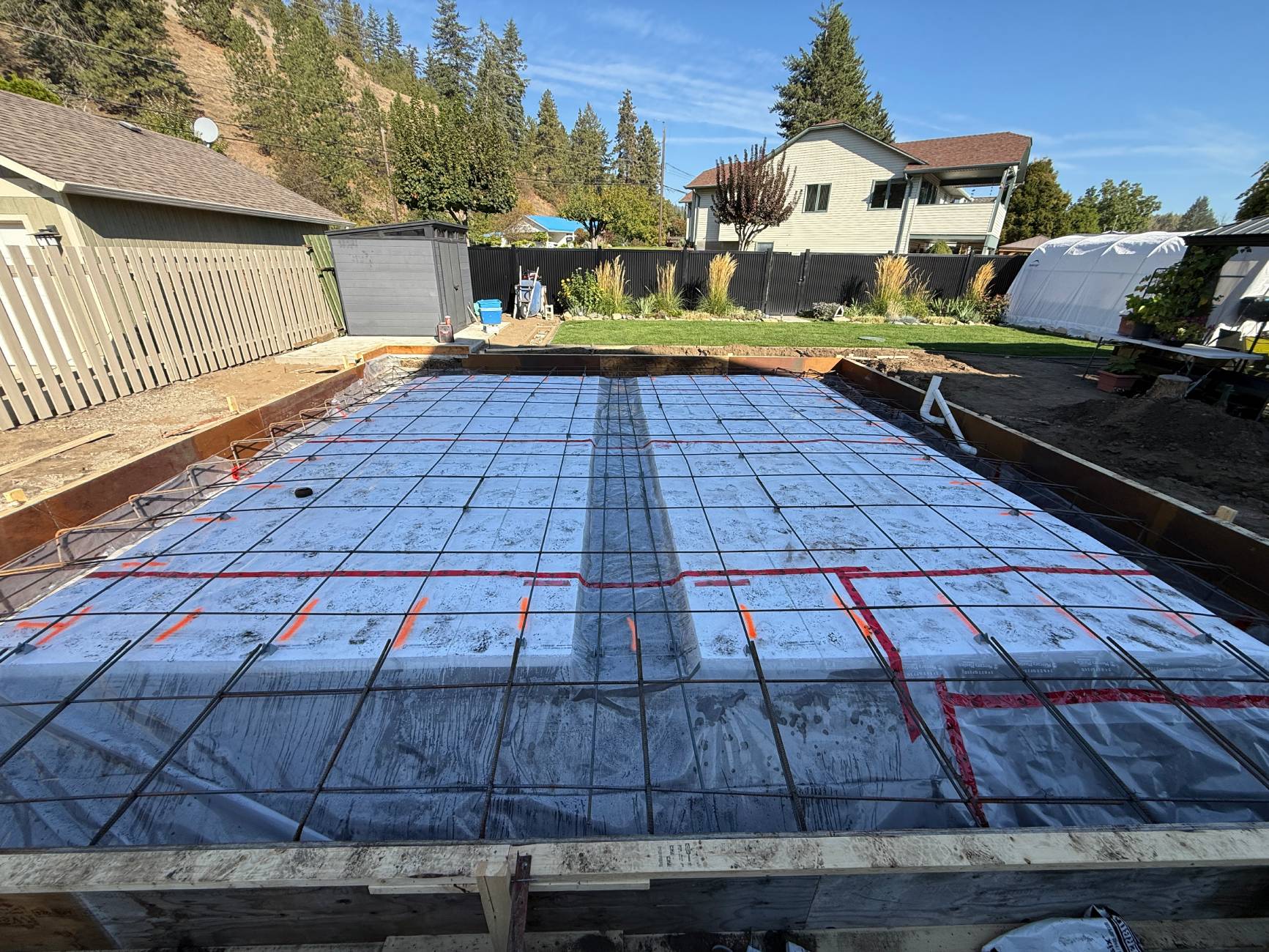 Concrete foundation prep in residential backyard.