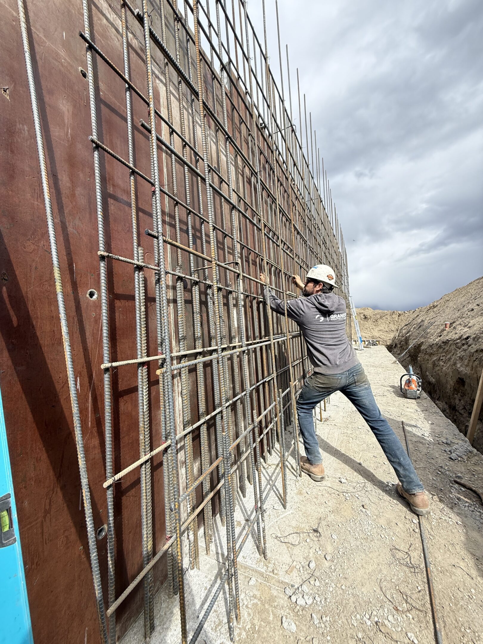 Construction worker installing steel reinforcement bars.