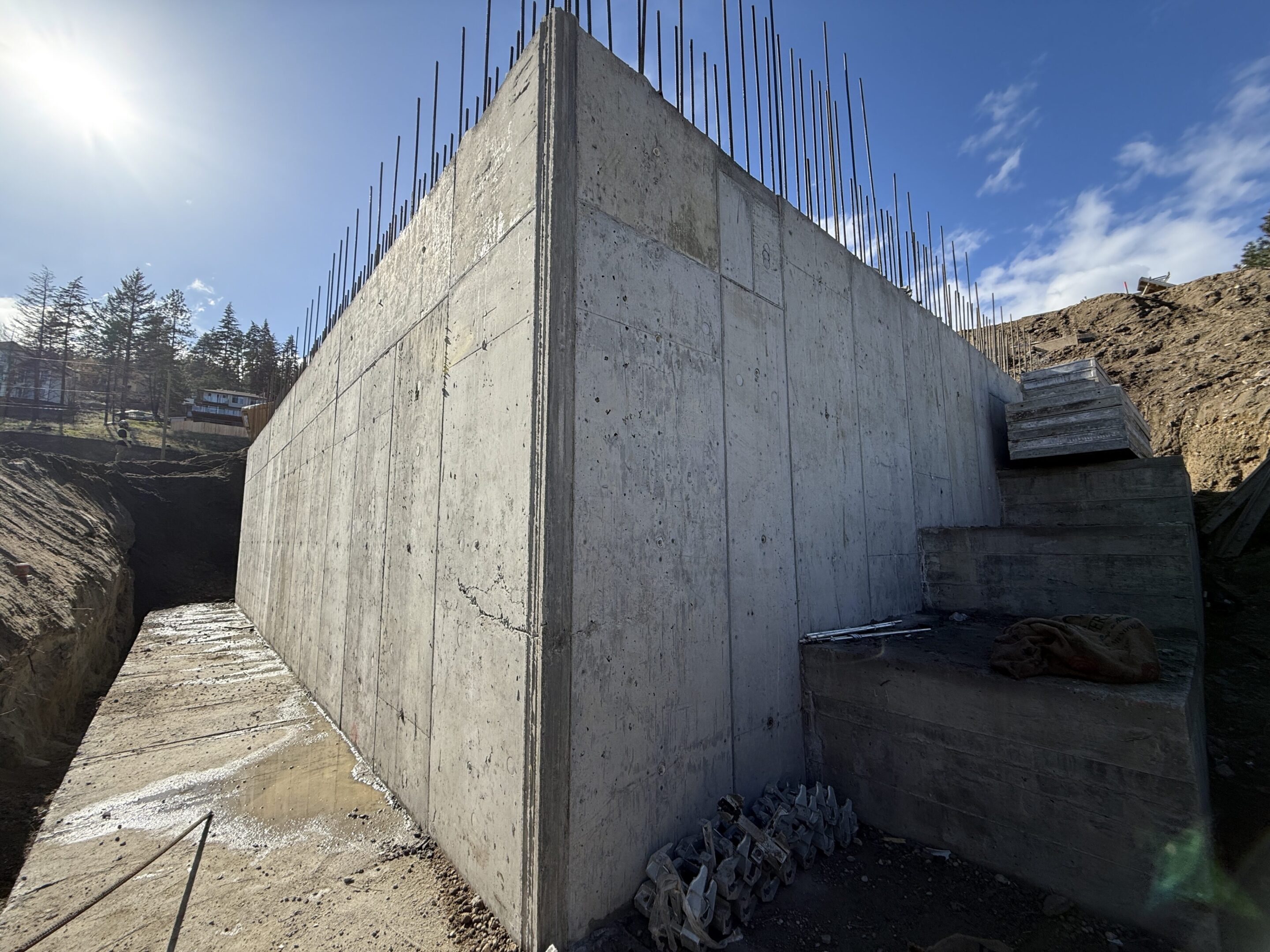 Concrete wall under construction with rebar exposed.
