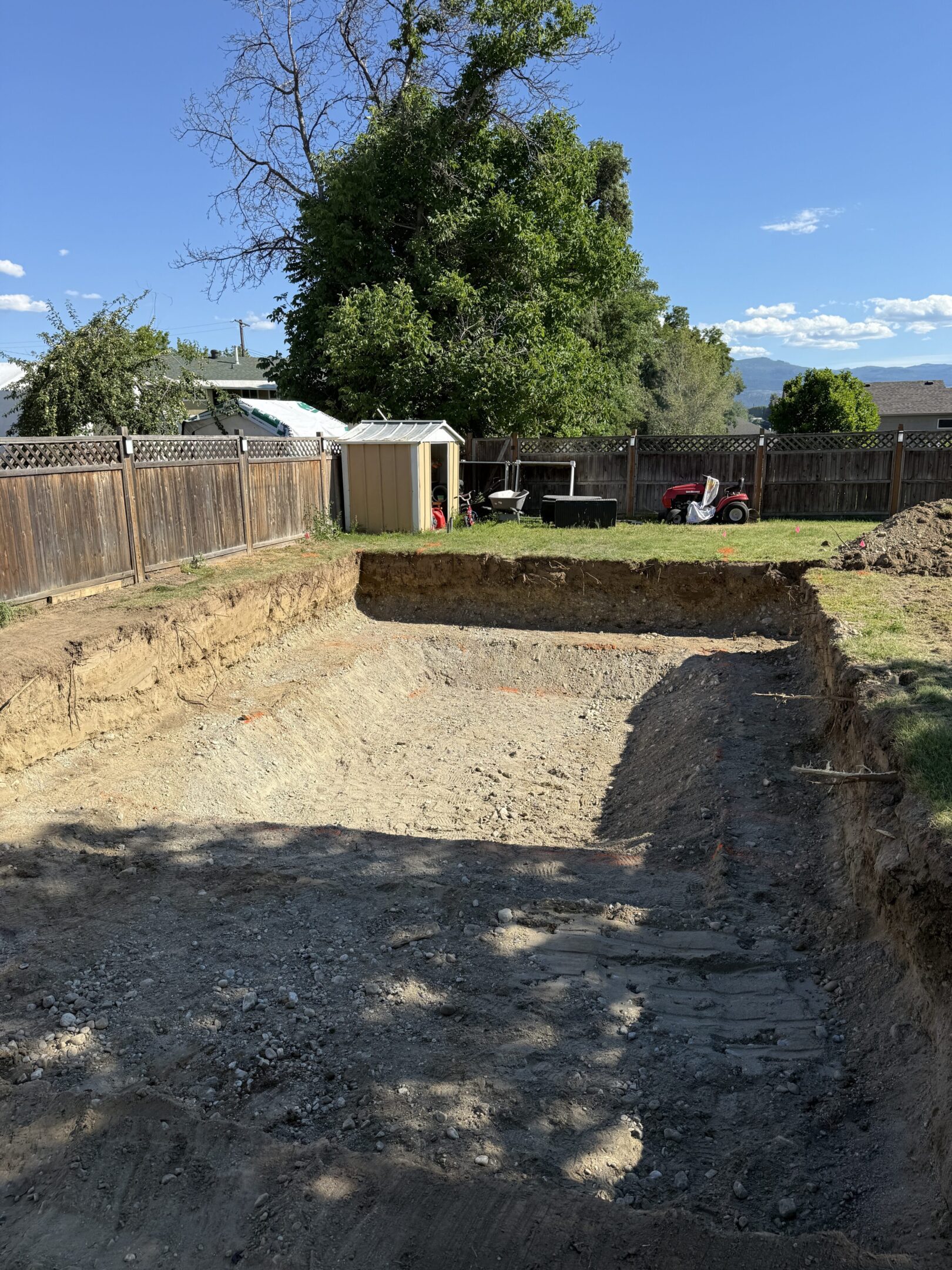 Empty rectangular pit in a backyard.