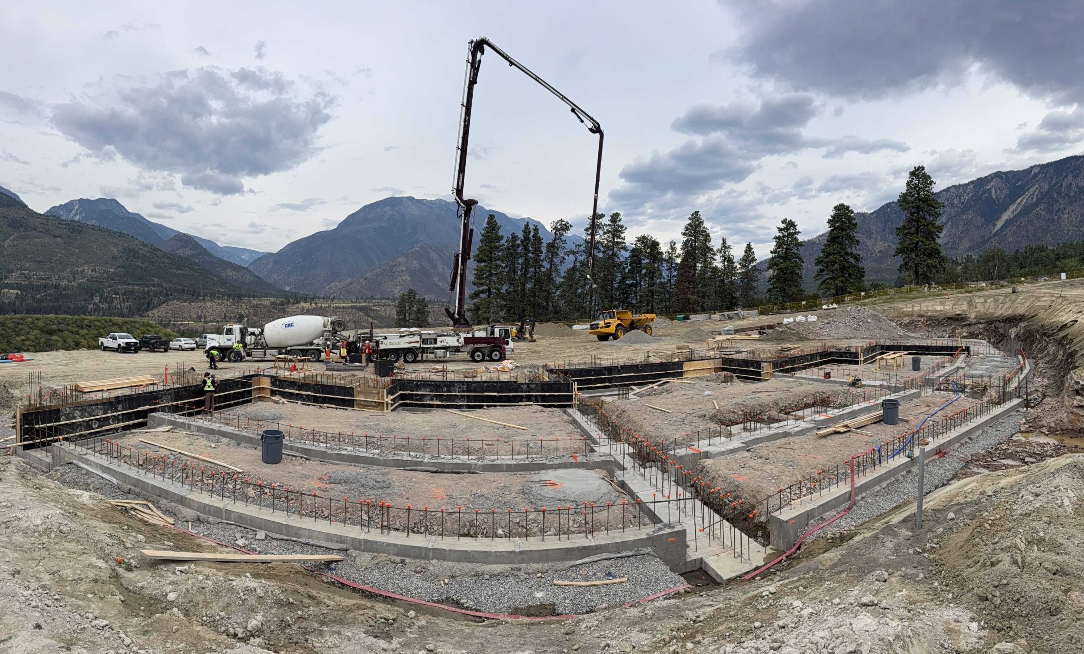 Construction site with mountains and machinery.