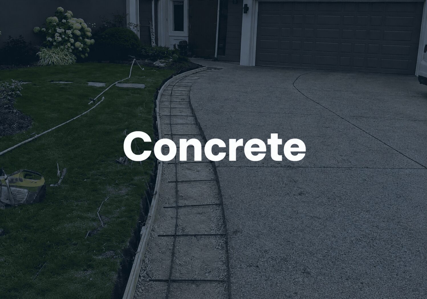Concrete driveway with grass and flowers.